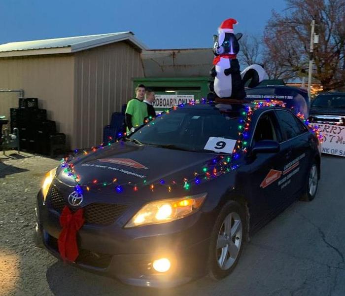 Eric at the Salina Christmas Parade with our mascot Lilly on the roof. Some of our candy throwers in the backgrond. 