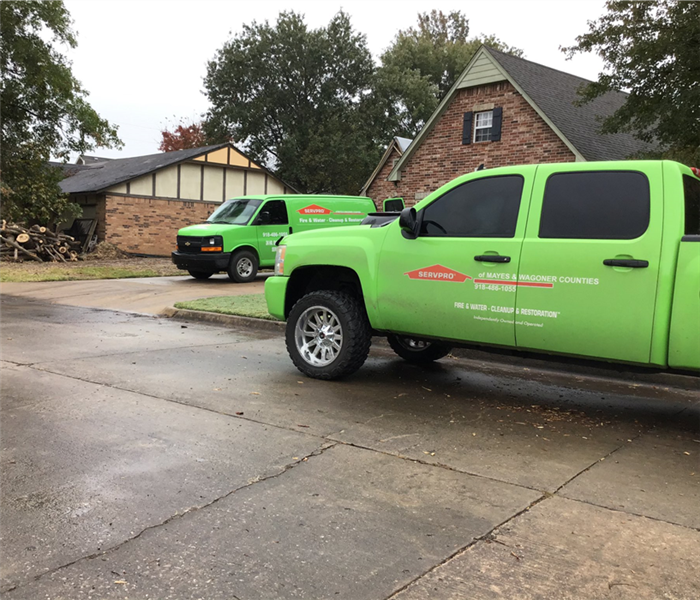 The team's official SERVPRO vehicles out in front of houses